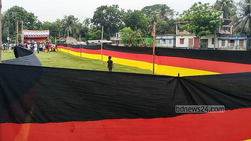 জার্মানি ফুটবল দলের ভক্ত মাগুরার আমজাদ হোসেন। এবার বিশ্বকাপের শুরুতে পছন্দের দলের সমর্থনে সাড়ে সাত কিলোমিটার পতাকা বানিয়েছেন তিনি; তাও আবার জমি বিক্রির টাকা দিয়ে। ছবি: বিডিনিউজ টোয়েন্টিফোর ডটকম