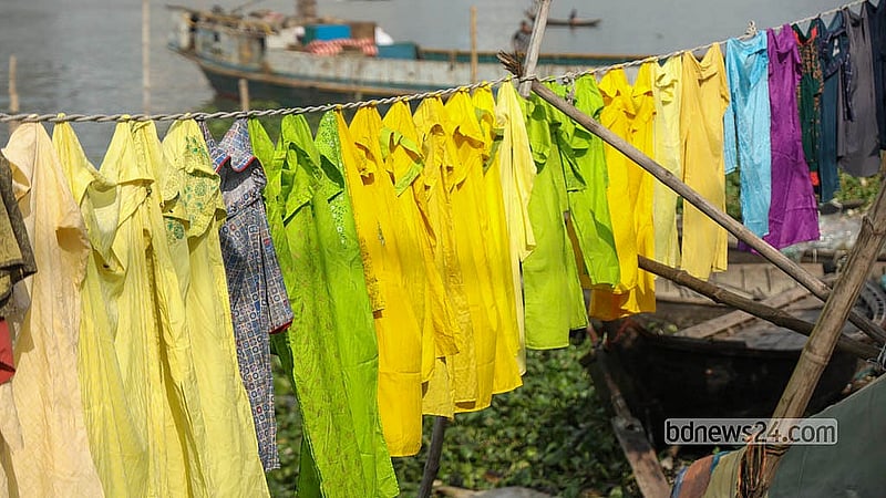 বুড়িগঙ্গার নদীর পানিতে ধোয়ার পর পাড়েই শুকিয়ে ফেলা হচ্ছে শত শত রঙিন পোশাক