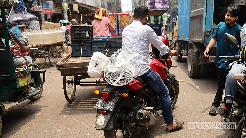 ঢাকার নবাবপুর থেকে রিচার্জেবল ফ্যান কিনে মোটরসাইকেলে করে বাসায় ফিরছেন এক ক্রেতা