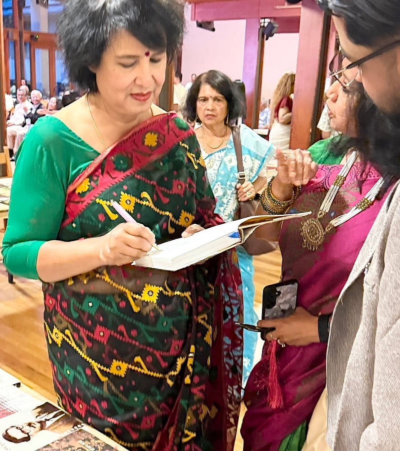 মেলায় আসা পাঠককে অটোগ্রাফ দিচ্ছেন তসলিমা।