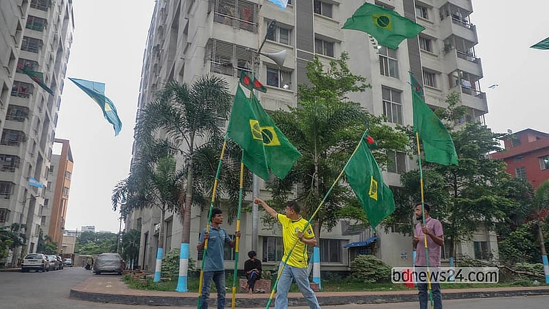ঢাকায় তেজগাঁও সরকারি কর্মকর্তা-কর্মচারী কোয়ার্টারে ব্রাজিলের পতাকা টানাচ্ছেন সমর্থকরা