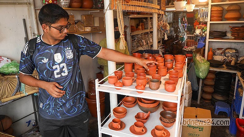 ঢাকার দক্ষিণ কেরানীগঞ্জের একটি দোকানে এসে মাটির তৈরি চায়ের কাপ দেখছেন এক তরুণ ক্রেতা