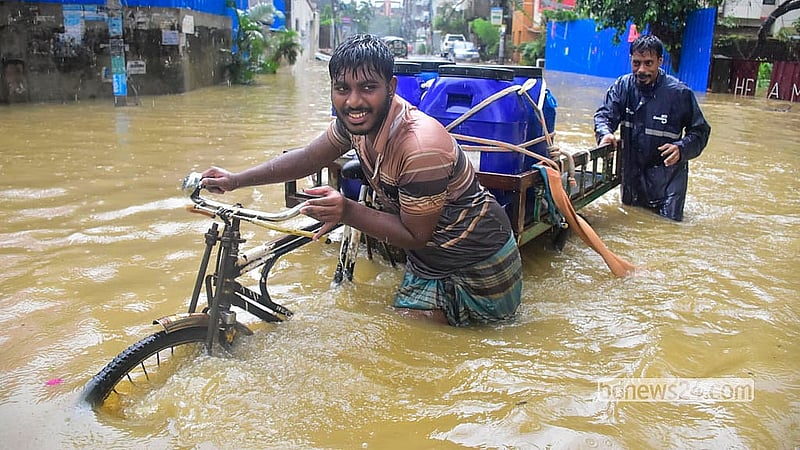 চট্টগ্রামের কাতালগঞ্জের সড়কে বুধবার দুপুরে কোমরপানি মাড়িয়ে চলতে দেখা যায় নগরবাসীকে