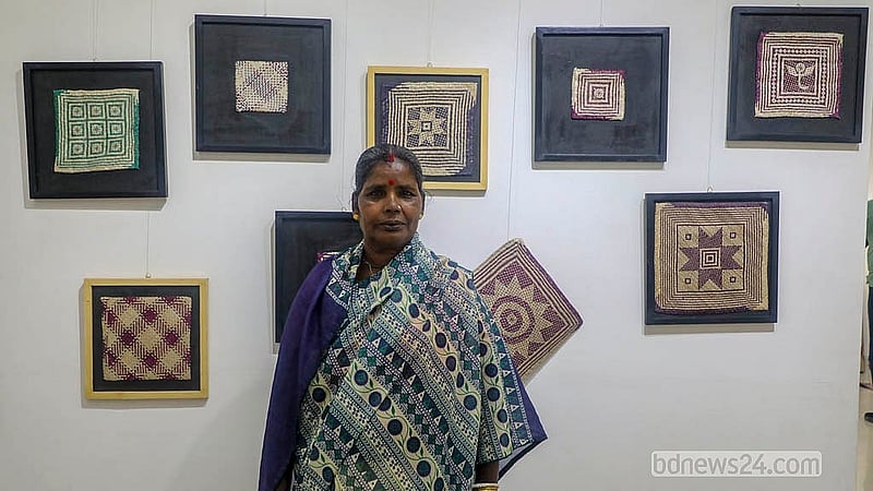 নিজের তৈরি শীতলপাটির পণ্যে সামনে দাঁড়ানো মৌলভীবাজারের আরতী রানী দাস