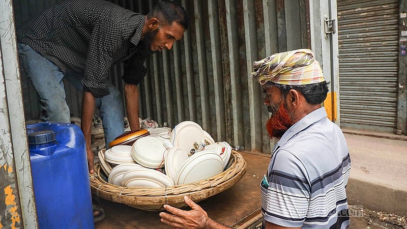 ঢাকার নবাবপুর রোডে পুরনো ইলেকট্রিক পণ্যের কনটেইনার থেকে সেকেন্ড হ্যান্ড সিলিং ফ্যান আনলোড করছেন শ্রমিকরা