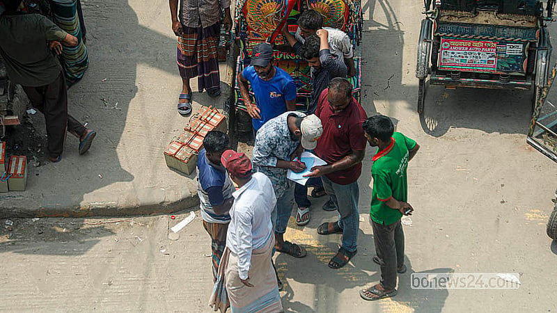 রাজধানীর পোস্তগোলা সেতুর উত্তর পাশে ডাম্পিং স্টেশনের সামনে মামলার কাগজে সই করছেন এক চালক