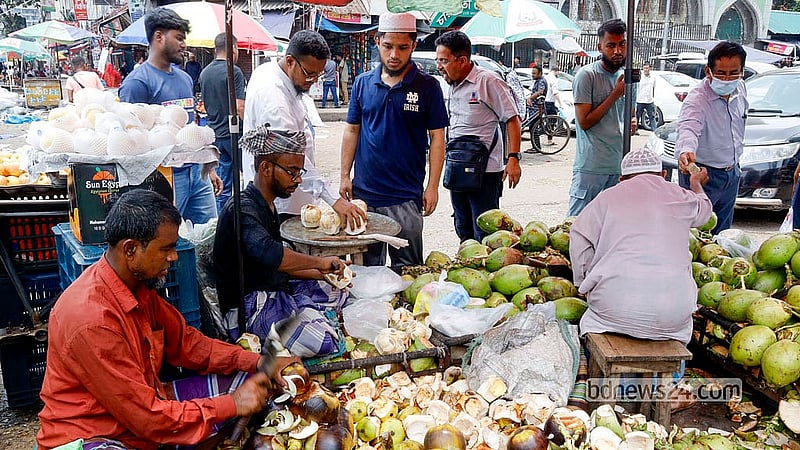 রাজধানীর কারওয়ান বাজারে বুধবার দুপুরে ডাব ও তালের শাঁসের দোকানে পথচারীদের ভিড় দেখা যায়