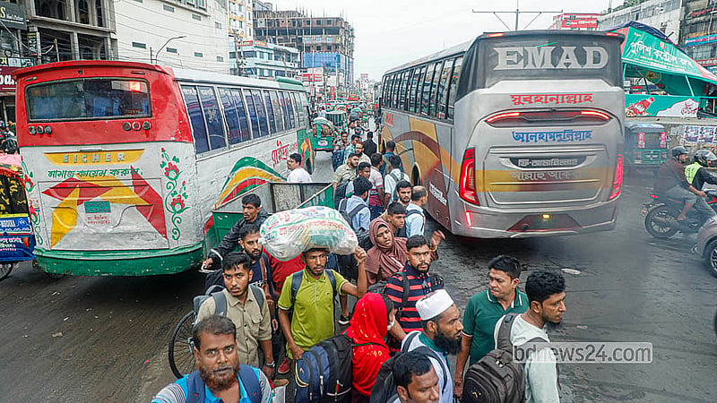 রাজধানীর দোলাইরপাড়ে মঙ্গলবার বাসের অপেক্ষায় সড়ক বিভাজকের মাঝে দাঁড়িয়ে যাত্রীরা