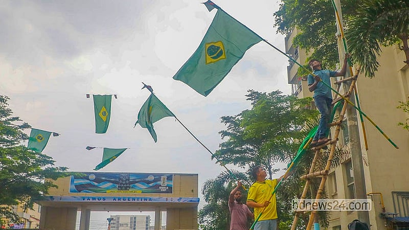 ঢাকায় তেজগাঁও সরকারি কর্মকর্তা-কর্মচারী কোয়ার্টারে ব্রাজিলের পতাকা টানাচ্ছেন সমর্থকরা