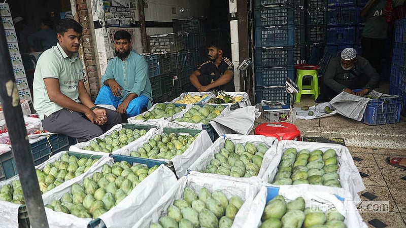 রাজধানীর বাদামতলী ফলের পাইকারি আড়তে বিক্রির জন্য সাজিয়ে রাখা হয়েছে আম