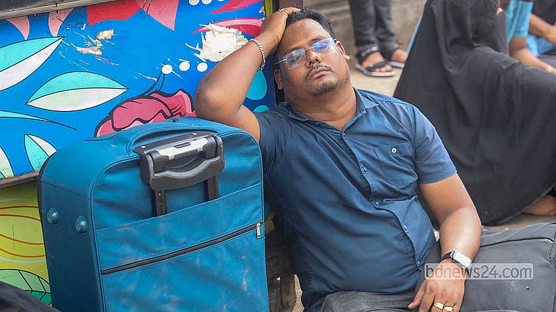 দীর্ঘ প্রতীক্ষার পর ট্যুরিস্ট ভিসা চালু হলেও আবেদনকারীদের পোহাতে হচ্ছে  ভোগান্তি; ভোর থেকে লাইনে দাঁড়িয়ে ক্লান্ত হয়ে যমুনা ফিউচার পার্কের ভিসা কেন্দ্রের বাইরে সুটকেসে হেলান দিয়ে বিশ্রাম নিচ্ছেন এক ব্যক্তি