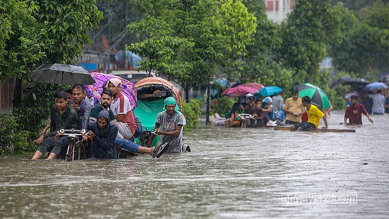 ঢাকার নিউ মার্কেটের সামনে রোববার কোমর সমান পানিতে ঝুঁকি নিয়ে চলাচল করে অনেক মানুষ।