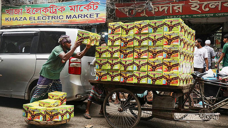 ঢাকার নবাবপুর রোডে ইলেকট্রিক পণ্যের পাইকারি বাজারে কার্টনভর্তি ফ্যান লোড-আনলোডে ব্যস্ত এক শ্রমিক