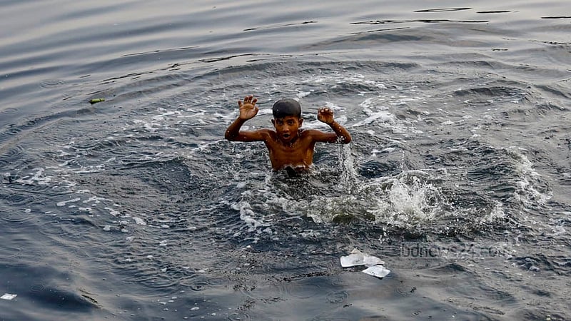 কামরাঙ্গীরচরের পাশ দিয়ে বয়ে যাওয়া বুড়িগঙ্গা নদীর কালো পানিতে গোসলের ছলে খেলায় মেতেছে এক শিশু