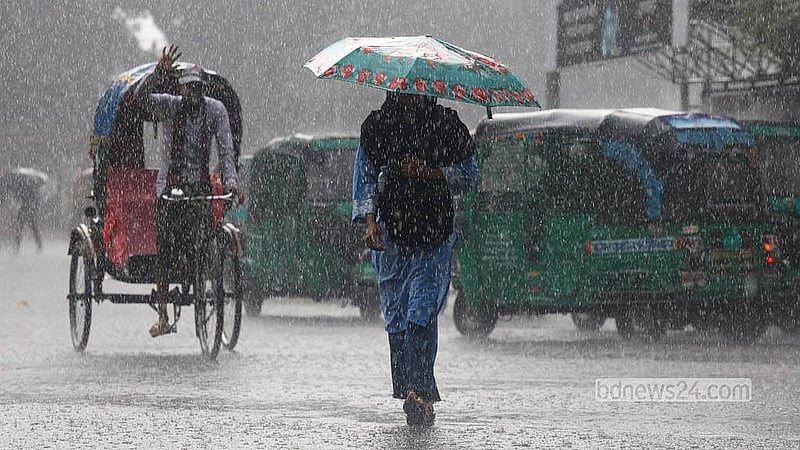 মুষলধারে বৃষ্টিতে ছাতা মাথায় গন্তব্যে ছুটছেন নগরবাসী। ঢাকা বিশ্ববিদ্যালয় এলাকা থেকে তোলা