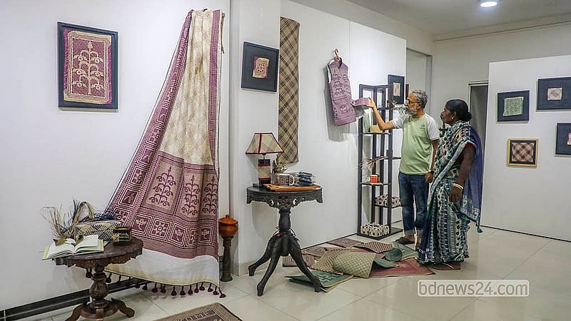 শীতলপাটির তৈরি বিভিন্ন পণ্য ঘুরে দেখছেন দর্শনার্থীরা। পছন্দ হলে কেনাকাটা করছেন কেউ কেউ