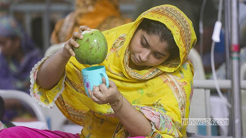 মুগদা মেডিকেল কলেজ হাসপাতালে ডেঙ্গু আক্রান্ত সন্তানের জন্য ডাবের পানি মগে ঢালছেন মা
