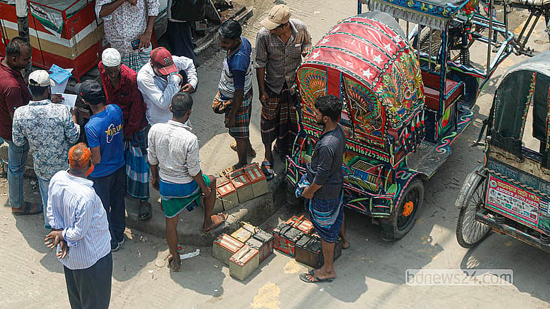 ডাম্পিং স্টেশনে রাখা রিকশা থেকে ব্যাটারি খুলে নিয়ে যাচ্ছেন চালকেরা