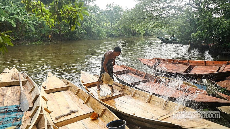 পিরোজপুরের কুড়িয়ানা খালে ঐতিহ্যবাহী নৌকার হাটে বিক্রির জন্য আনা কাঠের নৌকা ধুয়ে-মুছে আকর্ষণীয় করে তুলছেন বিক্রেতারা