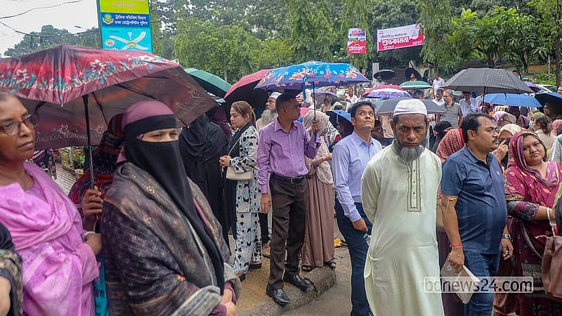 গরম আর গুড়িগুড়ি বৃষ্টির মধ্যে বৃহস্পতিবার সকালে মতিঝিল টিঅ্যান্ডটি কলেজ এইচএসসি পরীক্ষা কেন্দ্রের বাইরে ছাতা মাথায় দাঁড়িয়ে অভিভাবকরা