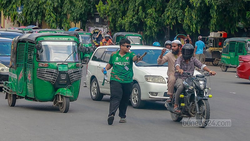 পুলিশবিহীন রাজধানীর সড়কে বুধবার যান নিয়ন্ত্রণের কাজ করছেন এক শিক্ষার্থী