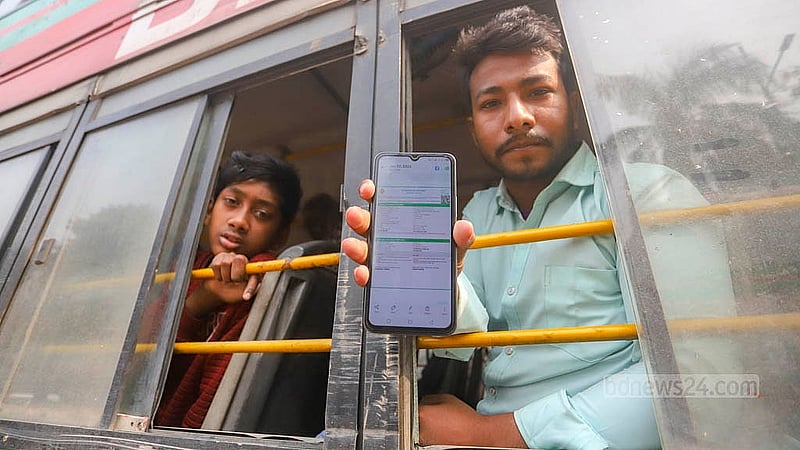 বাসে বসে ট্রেনের টিকেট দেখাচ্ছেন এক যাত্রী। রেলের রানিং স্টাফরা কর্মবিরতিতে থাকায় বন্ধ রয়েছে রেল চলাচল