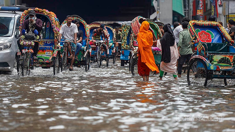 মিরপুরে রোববার সকালে টানা বৃষ্টিতে ডুবে যাওয়া সড়কে চলছেন পথচারী ও স্থানী বাসিন্দারা