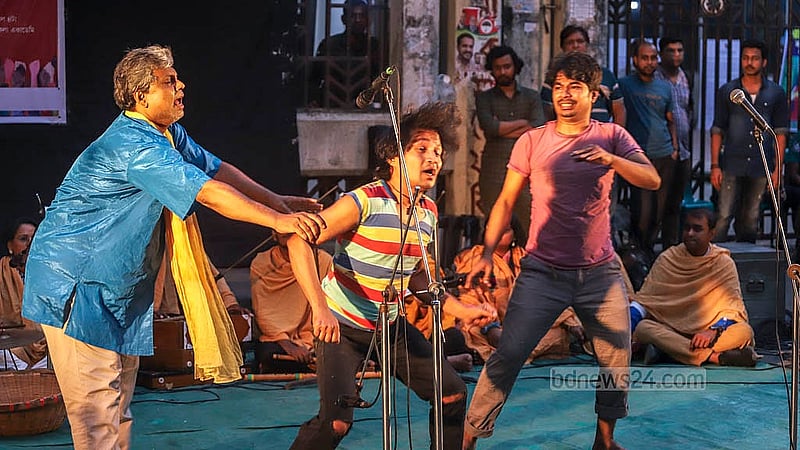 প্রতিবাদ সভায় হামলার প্রতিবাদ ও নাট্যকর্মীদের নিরাপত্তার দাবিতে বৃহস্পতিবার রাজধানীর শিল্পকলা একাডেমির জাতীয় নাট্যশালার ফটকে আরণ্যক নাট্যদলের ‘মূর্খ লোকের মূর্খ কথা’ পথনাটকের দৃশ্য