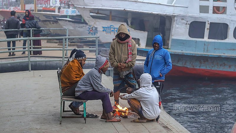 শীতের তীব্রতা বাড়ায় সদরঘাট লঞ্চ টার্মিনালের পন্টুনে বসে আগুন পোহাচ্ছেন কয়েকজন