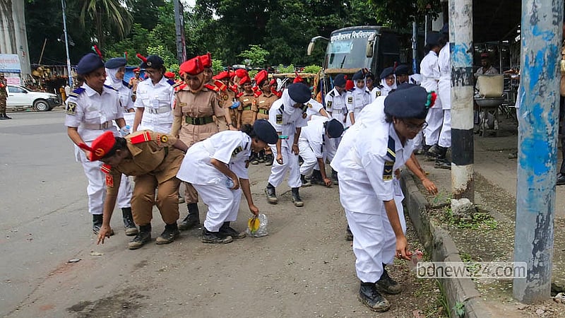 দেশজুড়ে তিন মাসব্যাপী ডেঙ্গু প্রতিরোধ ও পরিচ্ছন্নতা অভিযান কর্মসূচির অংশ হিসেবে শনিবার ঢাকার দোয়েল চত্বর এলাকায় পরিচ্ছন্নতা কার্যক্রমে অংশ নেন বাংলাদেশ ন্যাশনাল ক্যাডেট কোরসহ বিভিন্ন স্বেচ্ছাসেবী সংগঠনের সদস্যরা। এডিস মশার প্রজননস্থল ধ্বংস ও জনসচেতনতা বাড়াতে রাস্তাঘাট পরিষ্কার করছেন তারা।