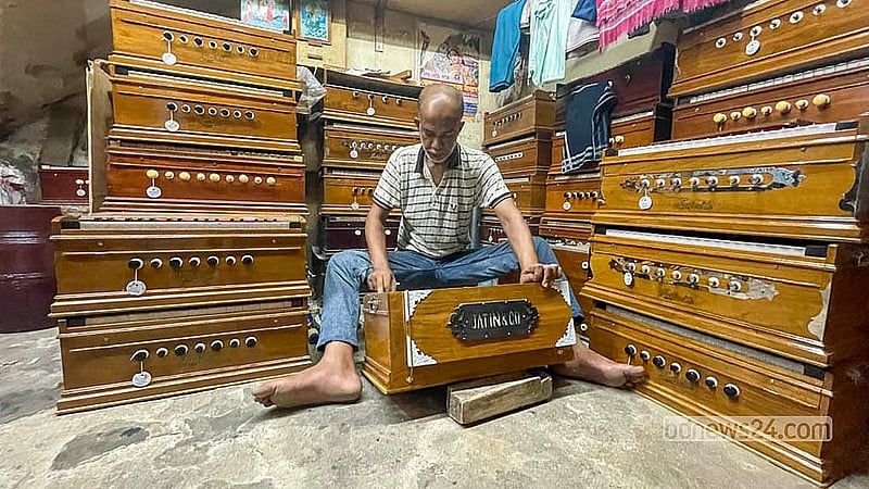 পুরান ঢাকার শাঁখারীবাজারে নিপুণ হাতে হারমোনিয়াম মেরামত ও সুর সামঞ্জস্য করছেন এক প্রবীণ কারিগর