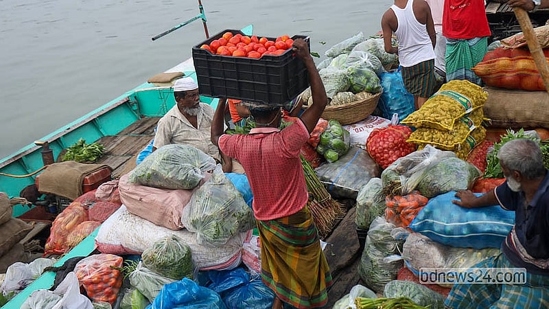 ঢাকার শ্যামবাজারের টমেটো মাথায় করে নিয়ে যাচ্ছে এক শ্রমিক