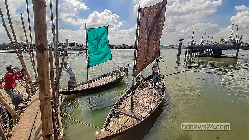 ঢাকায় বুড়িগঙ্গা নদীর মিল ব্যারাক ঘাটে যাত্রীর অপেক্ষায় পাল তোলা নৌকা