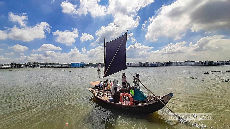 বুড়িগঙ্গা নদী পারাপারে শরতের নীল আকাশের নিচে পাল তুলে যাত্রী নিয়ে ছুটছেন মাঝি