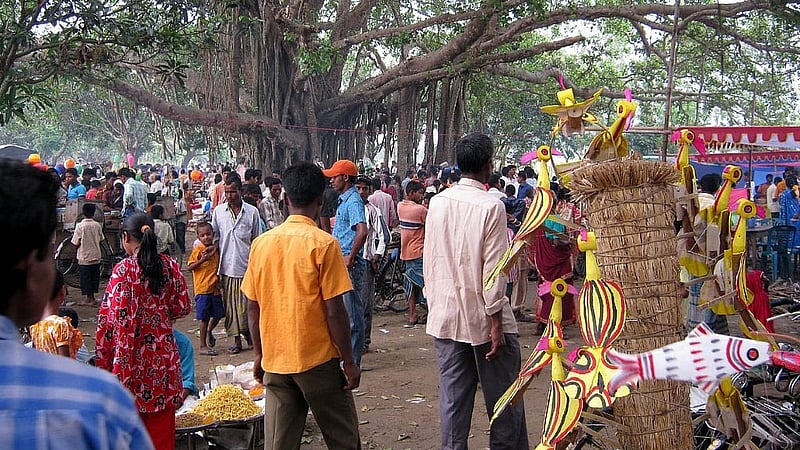 একপাশে রঙিন শামিয়ানা টাঙিয়ে বসেছে মিষ্টির দোকান। সেখানে মাটির চুলায় বড় কড়াইয়ে ফুটছে তেল, ছবি: লেখক।