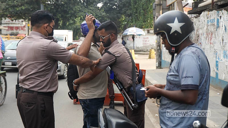 রাজধানীর মগবাজার ফ্লাইওভার এলাকায় চেকপোস্ট বসিয়ে এক মোটরসাইকেল আরোহীর দেহ তল্লাশি করছেন পুলিশ সদস্যরা। ছবি: শামছুল হক রিপন