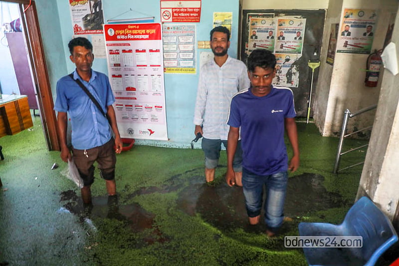 ঢাকার যাত্রাবাড়ীর মাতুয়াইল এলাকায় বিদ্যুৎ অফিস থেকে হাঁটু পানি মাড়িয়ে বের হচ্ছে মানুষ। &amp;nbsp;&amp;nbsp;ছবি: আব্দুল্লাহ আল মমীন