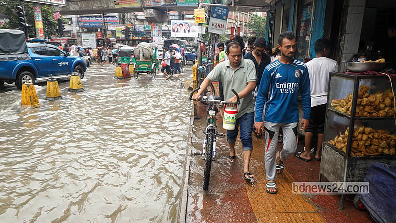 টানা বৃষ্টিতে ঢাকার বেইলি রোড এলাকায় সড়ক তলিয়ে যাওয়ায় সাইকেল ঠেলে নিয়ে যাচ্ছেন এক ব্যক্তি। ছবি: শামছুল হক রিপন
