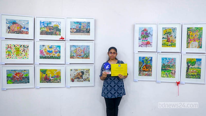 ঢাকা বিশ্ববিদ্যালয়ের চারুকলা অনুষদের জয়নুল গ্যালারিতে নিজের আঁকা ছবির সঙ্গে এক শিশু।&amp;nbsp;&amp;nbsp; ছবি: আব্দুল্লাহ আল মমীন