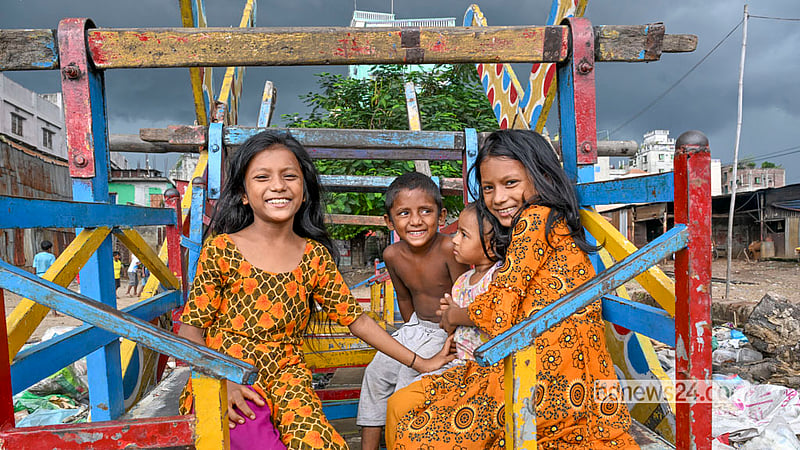 ঢাকার কেরাণীগঞ্জে বুড়িগঙ্গার তীরে ময়লার স্তূপ, পাশেই ফেলে রাখা নাগরদোলা—সেখানেই খেলায় মগ্ন কেরাণীগঞ্জের শিশুরা। ছবি: মোস্তাফিজুর রহমান