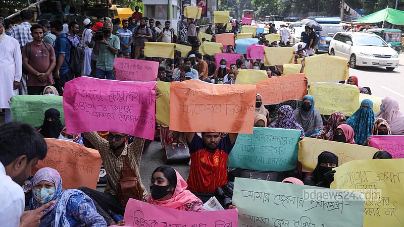 ঢাকার শাহবাগ থানার সামনে সড়কে বসে সহকারী শিক্ষক পদে দ্রুত নিয়োগপত্র দেওয়ার দাবিতে রোববার অবস্থান কর্মসূচি পালন করেন সুপারিশ পাওয়া প্রার্থীরা। ছবি: শামছুল হক রিপন