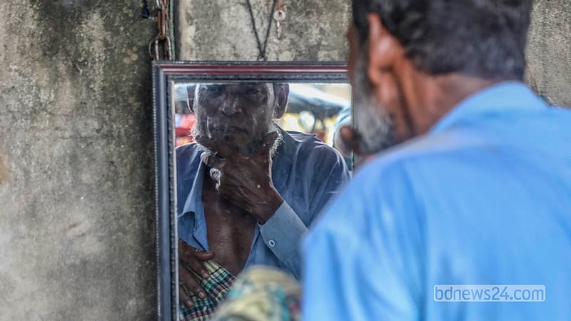 ঢাকার কেরাণীগঞ্জের আগানগর এলাকায় ভ্রাম্যমাণ নরসুন্দরের কাছে দাড়ি ছাঁটাইয়ের পর তা ঠিক আছে কি না, দেখছেন এক গ্রাহক। &amp;nbsp;&amp;nbsp;ছবি: আব্দুল্লাহ আল মমীন
