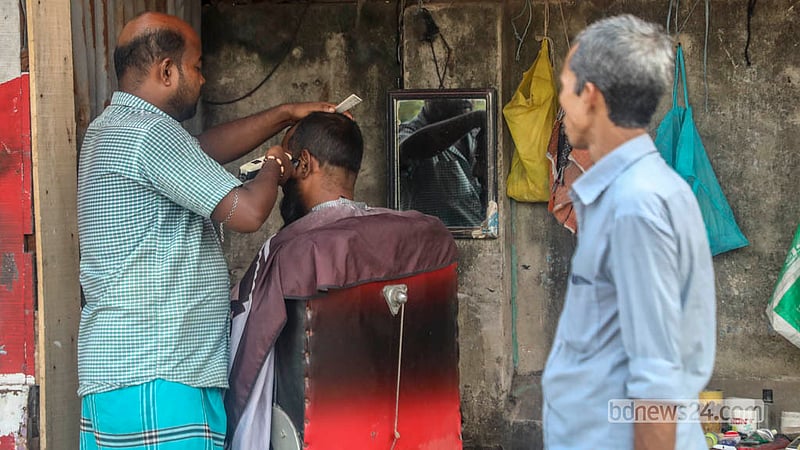 ঢাকার কেরাণীগঞ্জের আগানগর এলাকায় সড়কের পাশে বসা ভ্রাম্যমাণ নরসুন্দররা এখন কাঁচির সঙ্গে ব্যবহার করেন ট্রিমার।&amp;nbsp; ছবি: আব্দুল্লাহ আল মমীন