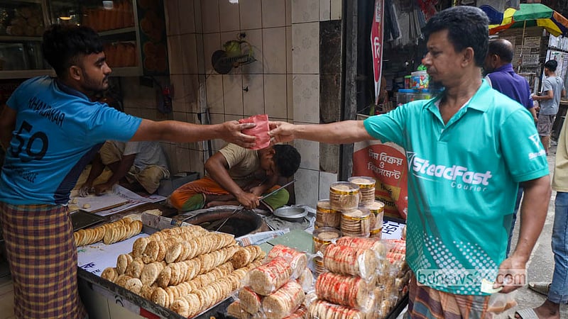 পুরান ঢাকার নাজিম উদ্দিন রোডের একটি দোকানে বাকরখানি কিনছেন এক ক্রেতা। ছবি: শামছুল হক রিপন