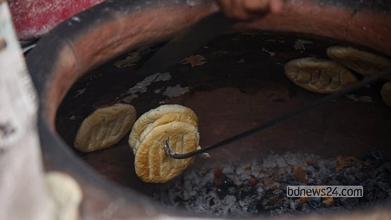 পুরান ঢাকার নাজিম উদ্দিন রোডে একটি দোকানে চুলা থেকে তোলা হচ্ছে বাকরখানি। ছবি: শামছুল হক রিপন