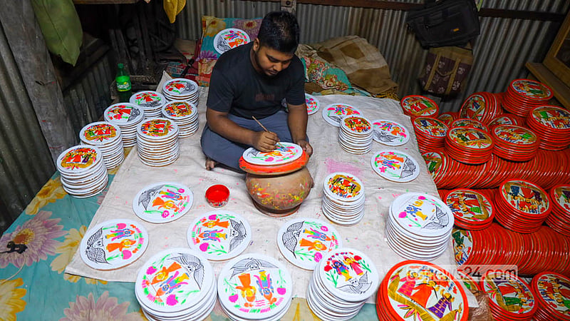 মুন্সীগঞ্জের সিরাজদিখানের পালপাড়ায় ‘লক্ষ্মী সরা’য় রঙের আঁচড় দিচ্ছেন এক মৃৎশিল্পী। ছবি: শামছুল হক রিপন