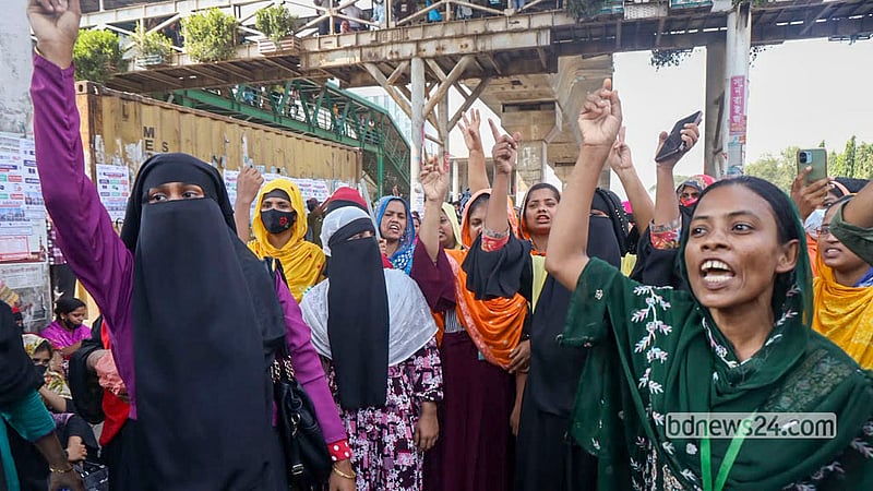 মজুরি বাড়ানোর দাবিতে বিভিন্ন পোশাক কারখানার শ্রমিকেরা বুধবার রাজধানীর উত্তরায় মহাসড়কে অবস্থান নিয়ে বিভিন্ন স্লোগান দেন। ছবি: শামছুল হক রিপন