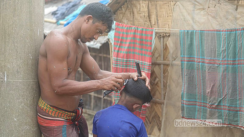 কাজের ফাঁকে সন্তানের মাথার চুল কেটে দিচ্ছেন ইটভাটার এক শ্রমিক।&amp;nbsp; ছবি: আব্দুল্লাহ আল মমীন