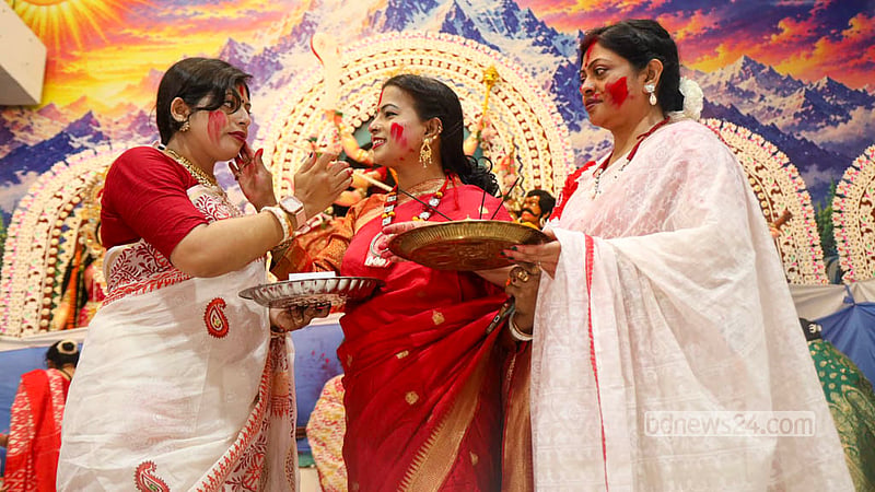 বিজয়া দশমীতে ঢাকেশ্বরী মন্দিরে দেবী দুর্গার চরণে দেওয়া সিঁদুর একে অপরের কপালে পরিয়ে দেন ভক্তরা। ছবি: শামছুল হক রিপন
