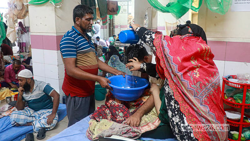 ডেঙ্গু নিয়ে ঢাকার মুগদা মেডিকেল কলেজ হাসপাতালে রোগীর মাথায় পানি ঢালছেন স্বজনরা। &amp;nbsp;&amp;nbsp;ছবি: আব্দুল্লাহ আল মমীন